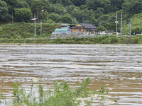 The isolated houses on the other side of the river that is overflowing to the danger level due to the heavy rain last night are being seen a...