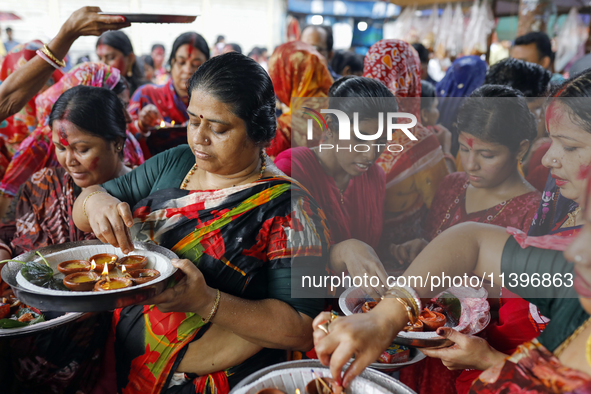 Hindu devotees are gathering beside the river Buriganga to float their lamps just after Bipodnashini Puja in Dhaka, Bangladesh, on July 09,...