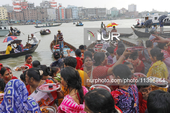 Hindu devotees are gathering beside the river Buriganga to float their lamps just after Bipodnashini Puja in Dhaka, Bangladesh, on July 09,...