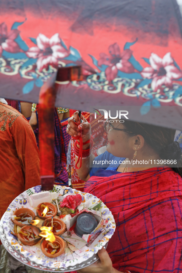 Hindu devotees are gathering beside the river Buriganga to float their lamps just after Bipodnashini Puja in Dhaka, Bangladesh, on July 09,...