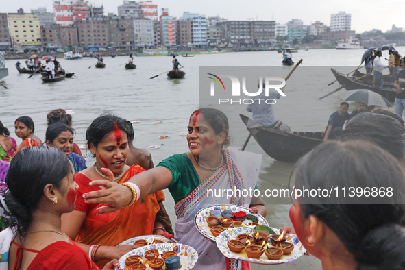 Hindu devotees are gathering beside the river Buriganga to float their lamps just after Bipodnashini Puja in Dhaka, Bangladesh, on July 09,...