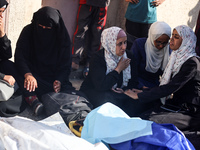 Palestinians are mourning over the bodies of loved ones following Israeli bombardment in Deir el-Balah in the central Gaza Strip on July 10,...