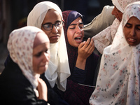 Palestinians are mourning over the bodies of loved ones following Israeli bombardment in Deir el-Balah in the central Gaza Strip on July 10,...