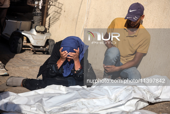 Palestinians are mourning over the bodies of loved ones following Israeli bombardment in Deir el-Balah in the central Gaza Strip on July 10,...