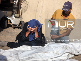 Palestinians are mourning over the bodies of loved ones following Israeli bombardment in Deir el-Balah in the central Gaza Strip on July 10,...