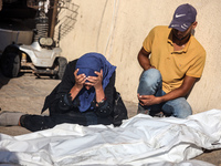 Palestinians are mourning over the bodies of loved ones following Israeli bombardment in Deir el-Balah in the central Gaza Strip on July 10,...