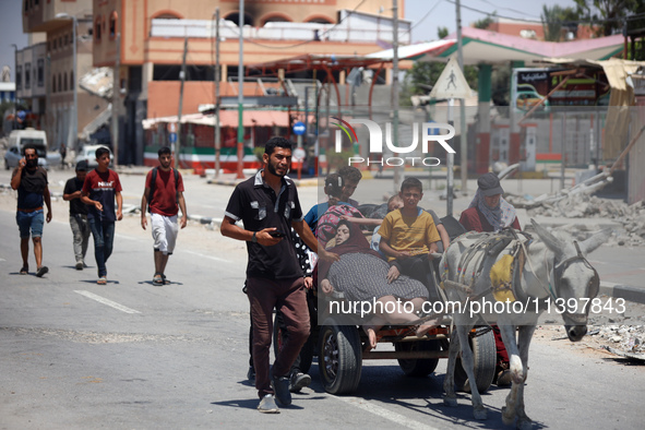 Displaced Palestinians are fleeing from Gaza City and are walking along Salah al-Din Street as they are arriving at the Nuseirat refugee cam...