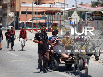 Displaced Palestinians are fleeing from Gaza City and are walking along Salah al-Din Street as they are arriving at the Nuseirat refugee cam...