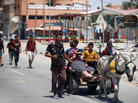 Displaced Palestinians are fleeing from Gaza City and are walking along Salah al-Din Street as they are arriving at the Nuseirat refugee cam...