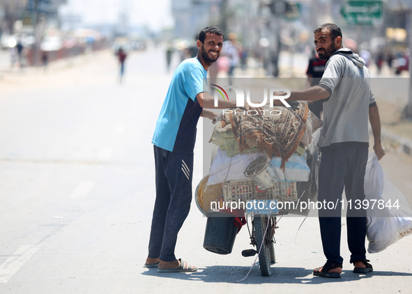 Displaced Palestinians are fleeing from Gaza City and are walking along Salah al-Din Street as they are arriving at the Nuseirat refugee cam...