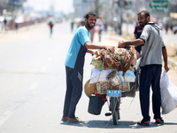 Displaced Palestinians are fleeing from Gaza City and are walking along Salah al-Din Street as they are arriving at the Nuseirat refugee cam...