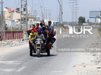 Displaced Palestinians are fleeing from Gaza City and are walking along Salah al-Din Street as they are arriving at the Nuseirat refugee cam...