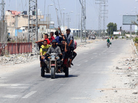 Displaced Palestinians are fleeing from Gaza City and are walking along Salah al-Din Street as they are arriving at the Nuseirat refugee cam...