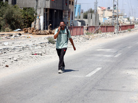 Displaced Palestinians are fleeing from Gaza City and are walking along Salah al-Din Street as they are arriving at the Nuseirat refugee cam...