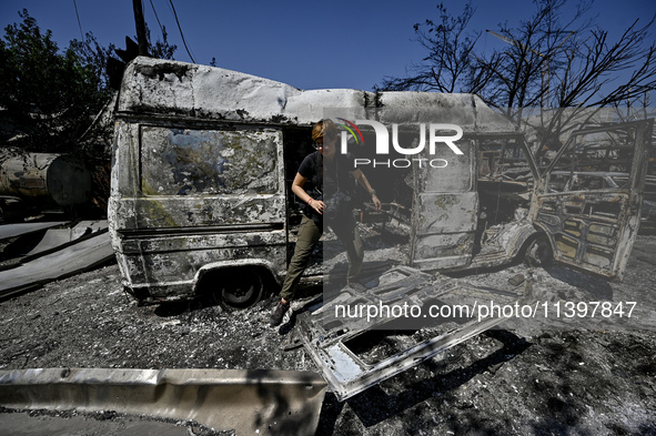 A journalist is standing in front of a van damaged by the July 8 Russian missile attack in Vilniansk, Zaporizhzhia region, southeastern Ukra...