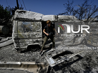 A journalist is standing in front of a van damaged by the July 8 Russian missile attack in Vilniansk, Zaporizhzhia region, southeastern Ukra...