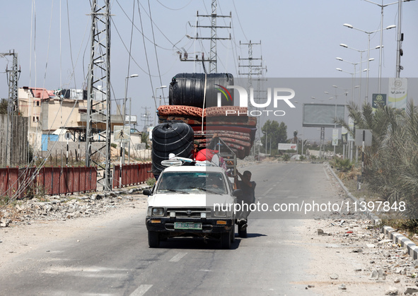 Displaced Palestinians are fleeing from Gaza City and are walking along Salah al-Din Street as they are arriving at the Nuseirat refugee cam...