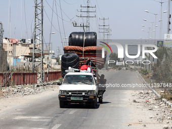 Displaced Palestinians are fleeing from Gaza City and are walking along Salah al-Din Street as they are arriving at the Nuseirat refugee cam...