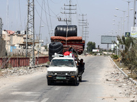 Displaced Palestinians are fleeing from Gaza City and are walking along Salah al-Din Street as they are arriving at the Nuseirat refugee cam...