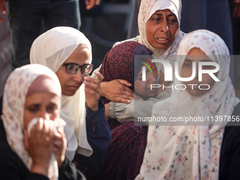 Palestinians are mourning over the bodies of loved ones following Israeli bombardment in Deir el-Balah in the central Gaza Strip on July 10,...