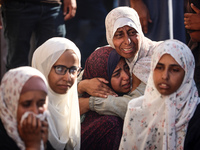 Palestinians are mourning over the bodies of loved ones following Israeli bombardment in Deir el-Balah in the central Gaza Strip on July 10,...