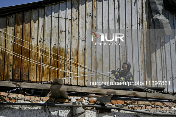 A firefighter is putting out a fire in a building damaged by the July 8 Russian missile attack in Vilniansk, Zaporizhzhia region, southeaste...