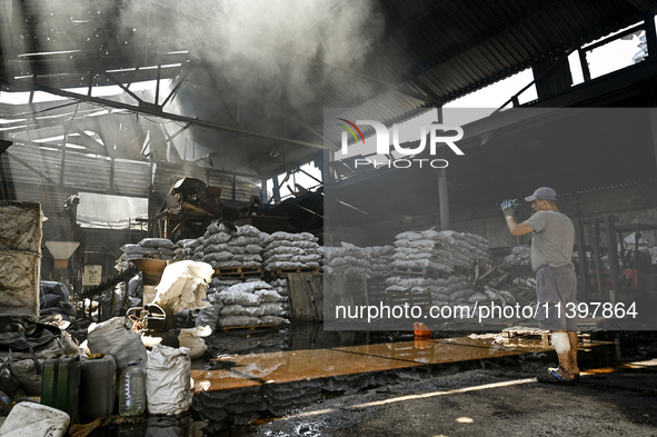 A man is standing in a hangar with agricultural products damaged by the July 8 Russian missile attack in Vilniansk, Ukraine, on July 9, 2024...