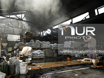 A man is standing in a hangar with agricultural products damaged by the July 8 Russian missile attack in Vilniansk, Ukraine, on July 9, 2024...