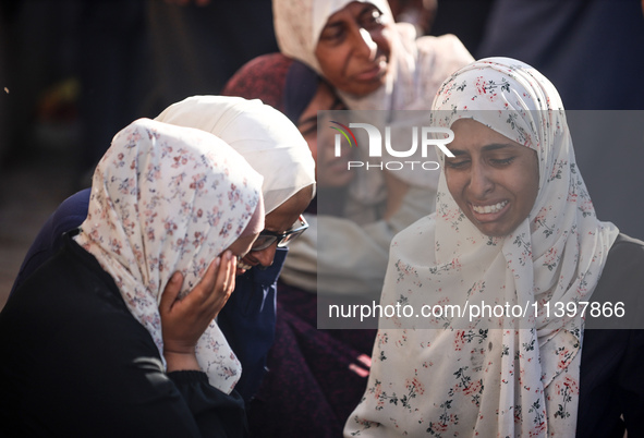 Palestinians are mourning over the bodies of loved ones following Israeli bombardment in Deir el-Balah in the central Gaza Strip on July 10,...