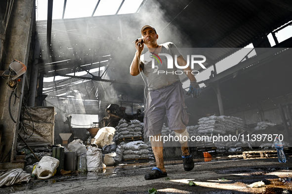 A man is standing in a hangar with agricultural products damaged by the July 8 Russian missile attack in Vilniansk, Ukraine, on July 9, 2024...