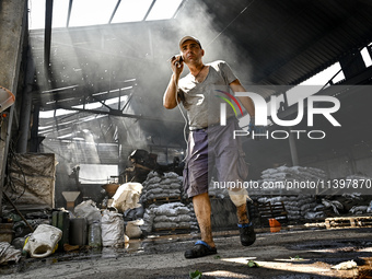 A man is standing in a hangar with agricultural products damaged by the July 8 Russian missile attack in Vilniansk, Ukraine, on July 9, 2024...