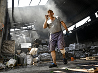 A man is standing in a hangar with agricultural products damaged by the July 8 Russian missile attack in Vilniansk, Ukraine, on July 9, 2024...