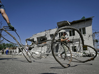 A man is holding a metal wire and looking at a building damaged by the July 8 Russian missile attack in Vilniansk, Zaporizhzhia region, sout...