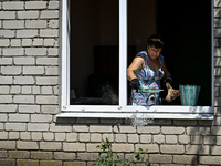 A woman is throwing away glass shards from a building damaged by the July 8 Russian missile attack in Vilniansk, Ukraine, on July 9, 2024. N...