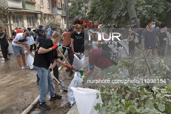 Locals are helping remove the rubble at a section of a five-storey apartment building in the Shevchenkivskyi district destroyed by the Russi...