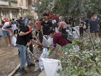 Locals are helping remove the rubble at a section of a five-storey apartment building in the Shevchenkivskyi district destroyed by the Russi...