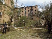 Police officers are staying near a section of a five-storey apartment block in the Shevchenkivskyi district destroyed by the Russian missile...