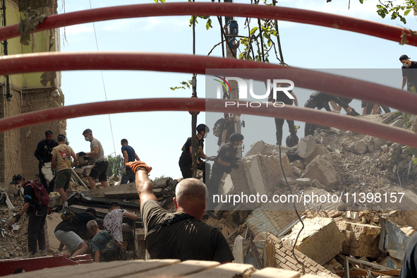 The ruins of a section of a five-storey apartment building in the Shevchenkivskyi district are being dismantled after the Russian missile at...