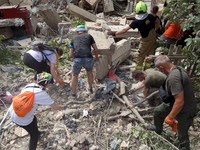 Locals are helping remove the rubble at a section of a five-storey apartment building in the Shevchenkivskyi district destroyed by the Russi...