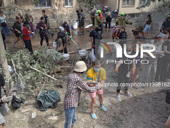 Locals are helping remove the rubble at a section of a five-storey apartment building in the Shevchenkivskyi district destroyed by the Russi...