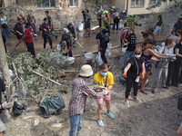 Locals are helping remove the rubble at a section of a five-storey apartment building in the Shevchenkivskyi district destroyed by the Russi...