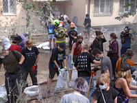 Locals are helping remove the rubble at a section of a five-storey apartment building in the Shevchenkivskyi district destroyed by the Russi...