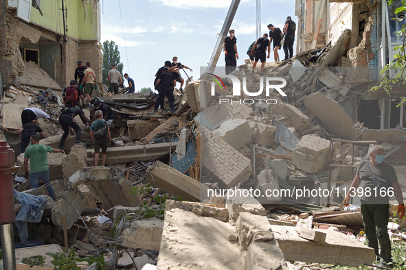 The ruins of a section of a five-storey apartment building in the Shevchenkivskyi district are being dismantled after the Russian missile at...