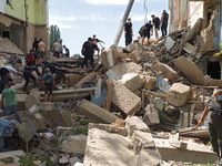 The ruins of a section of a five-storey apartment building in the Shevchenkivskyi district are being dismantled after the Russian missile at...