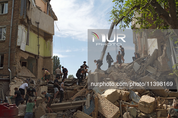 The ruins of a section of a five-storey apartment building in the Shevchenkivskyi district are being dismantled after the Russian missile at...