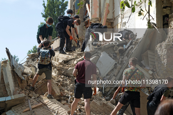 The ruins of a section of a five-storey apartment building in the Shevchenkivskyi district are being dismantled after the Russian missile at...