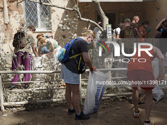 Locals are helping remove the rubble at a section of a five-storey apartment building in the Shevchenkivskyi district destroyed by the Russi...