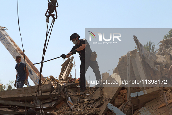 A police officer is removing the rubble at a five-storey apartment building in the Shevchenkivskyi district destroyed by the Russian missile...