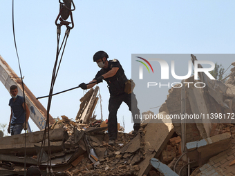 A police officer is removing the rubble at a five-storey apartment building in the Shevchenkivskyi district destroyed by the Russian missile...