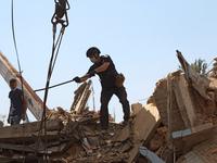 A police officer is removing the rubble at a five-storey apartment building in the Shevchenkivskyi district destroyed by the Russian missile...